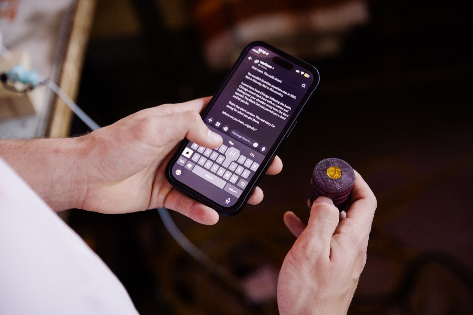 Hands holding a phone mid-conversation with an Edger’s character, the purple Edger in the other hand